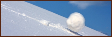 Large snowball rolling rapidly downhill